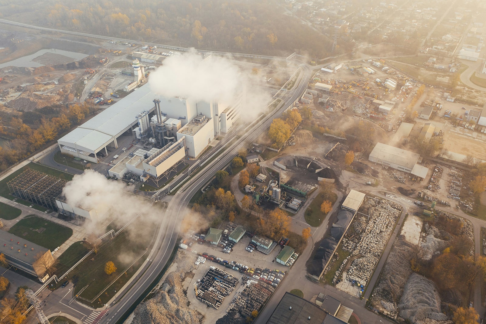 Early morning aerial photograph of a large industrial estate blanketed with plumes of white smoke