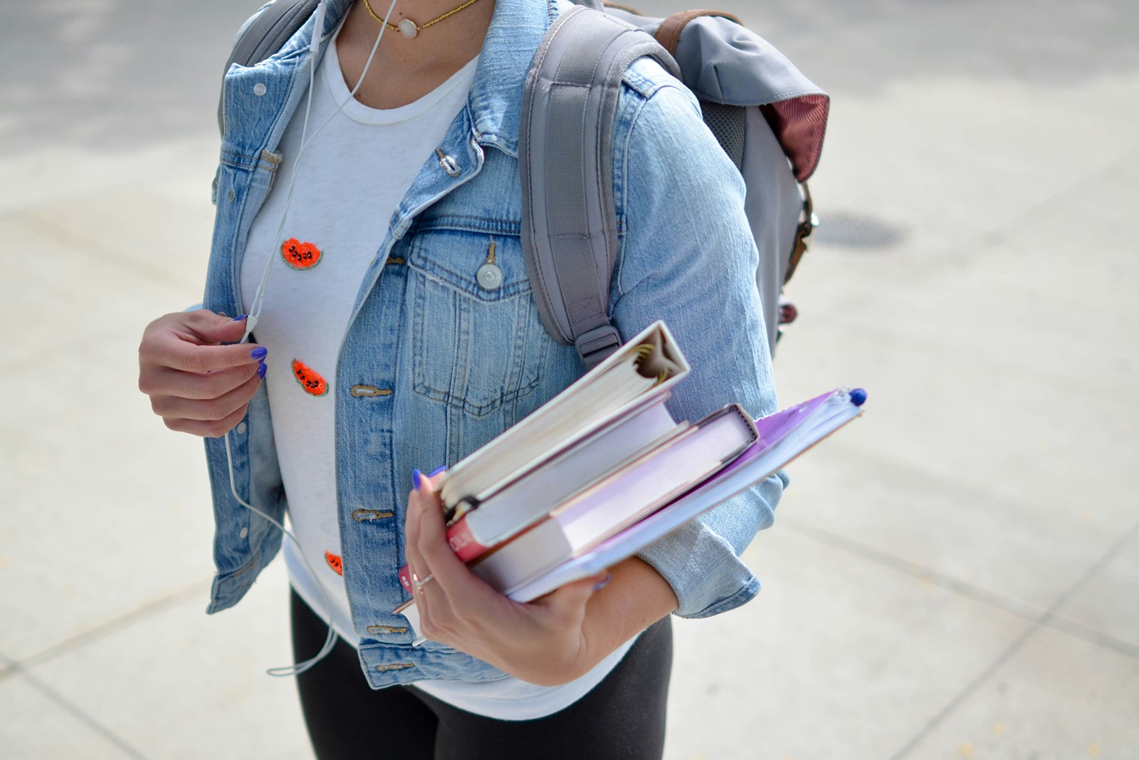 Young student wearing back pack and carrying books and binders