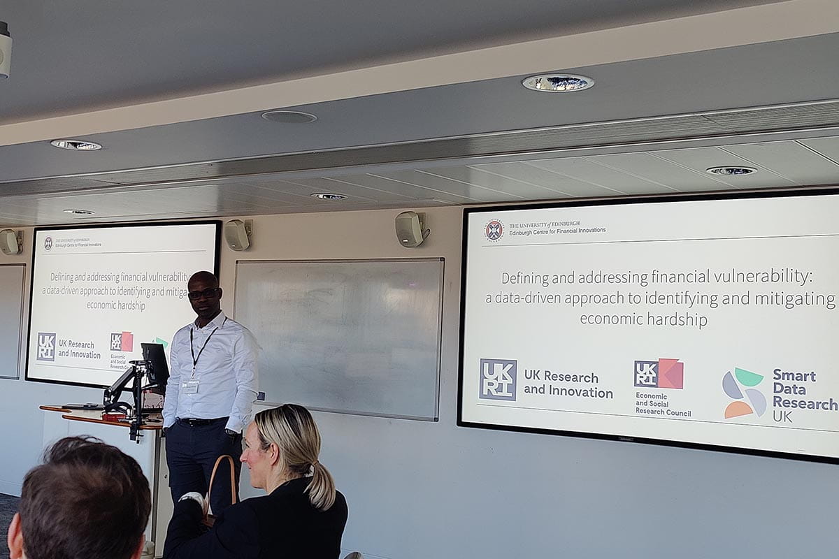 Presenter speaking in front of two screens at a workshop